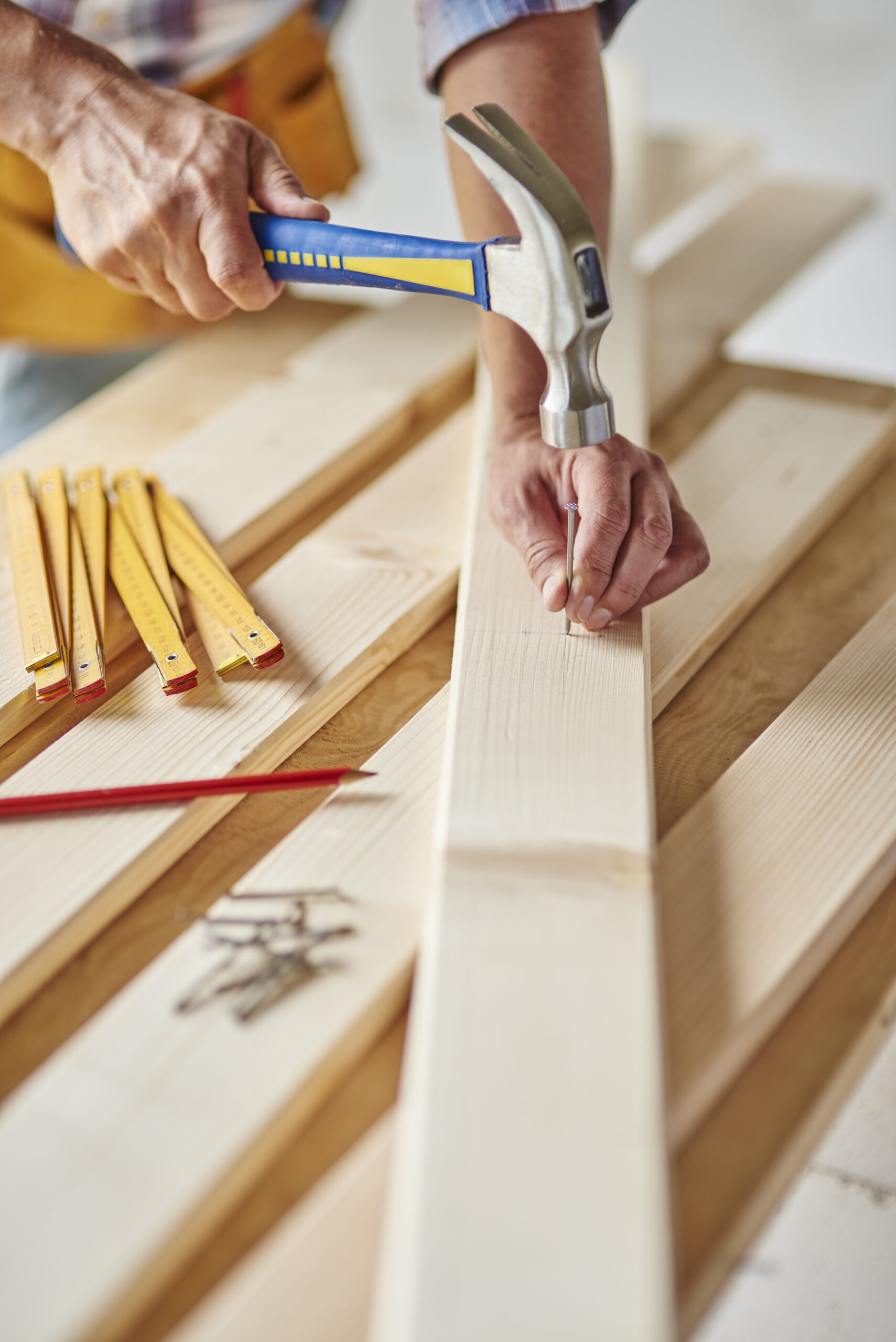 Carpenter with hammer hits wood